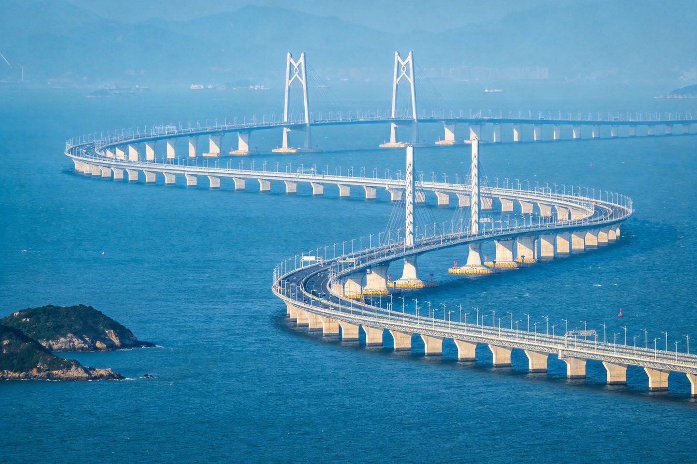 港珠澳大桥：横跨伶仃洋的跨海大桥，白色曲线桥身在碧蓝海面蜿蜒，桥塔与跨海段宏伟壮观