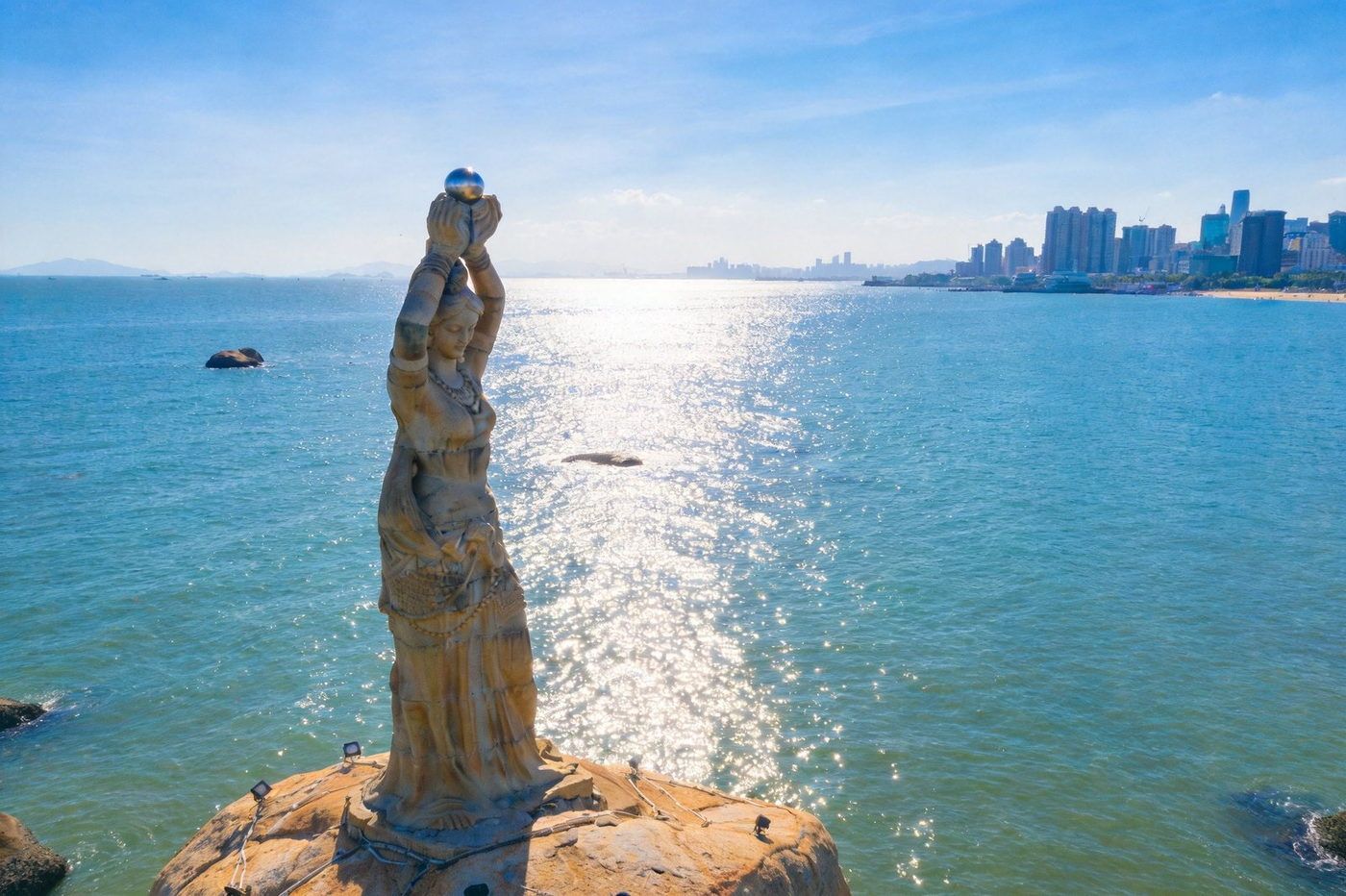 珠海渔女雕像：矗立在海边的珠海市标志性雕塑，传说中手捧珍珠的渔女像，面朝碧蓝海湾，远处城市天际线